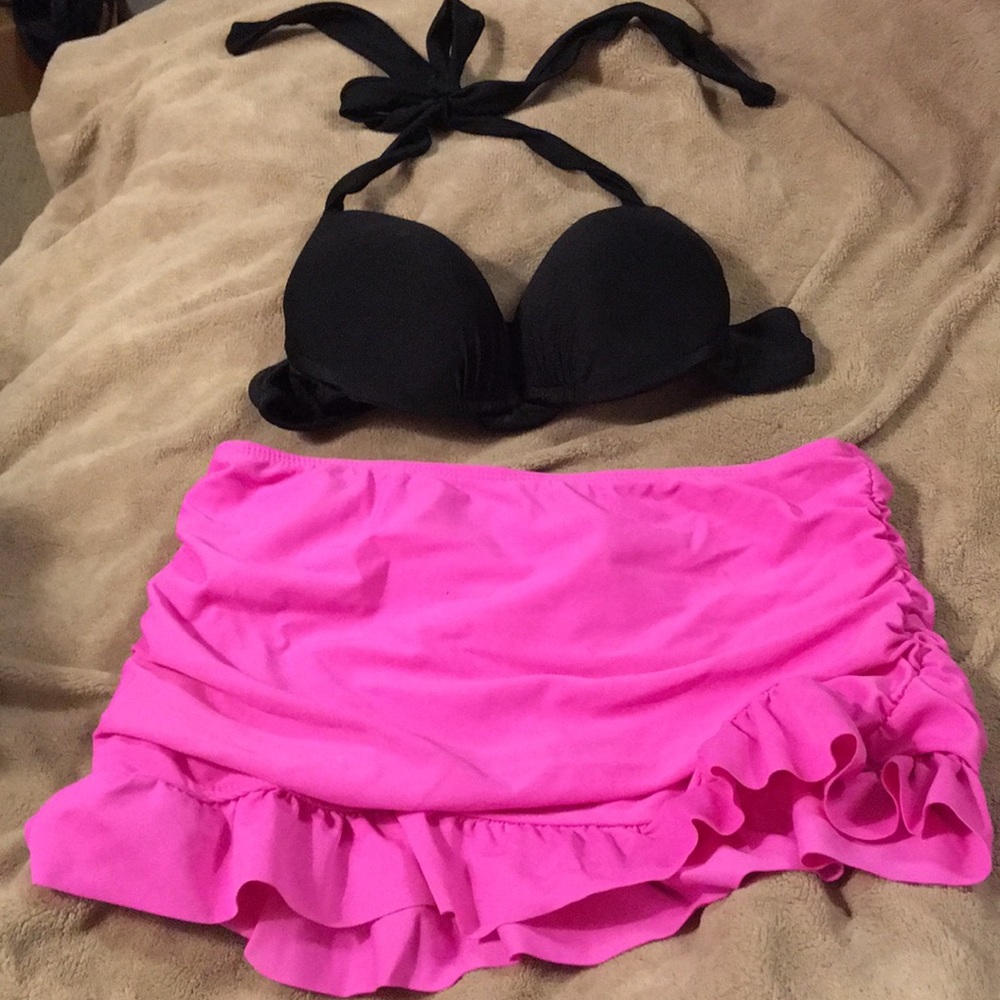 Women’s black bikini top and pink swim skirt.